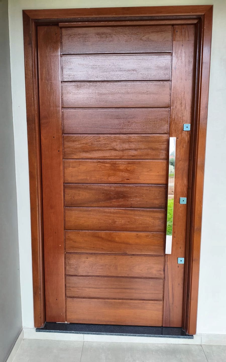 Porta pivotante de madeira com puxador de inox